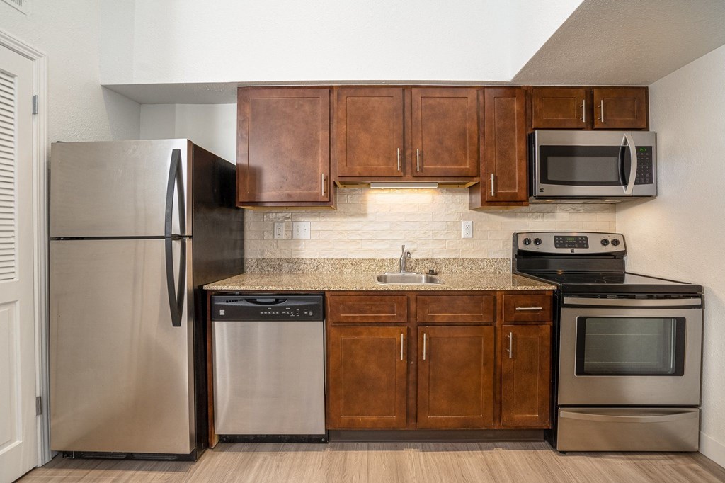 a kitchen with wooden cabinets and stainless steel appliances